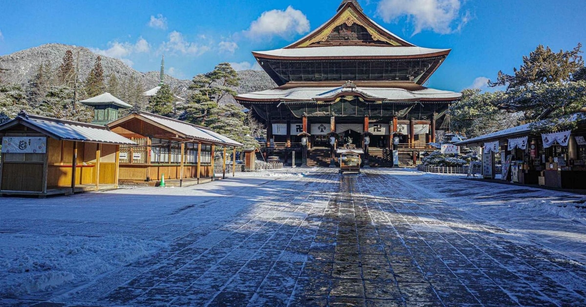 Zenkō-ji temple in Nagano under fresh snow beneath a blue sky